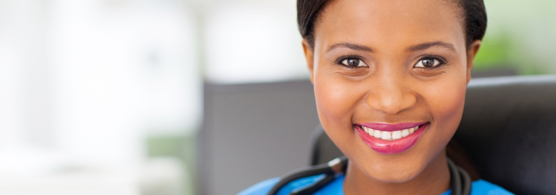 Woman wearing medical attire looking at camera smiling