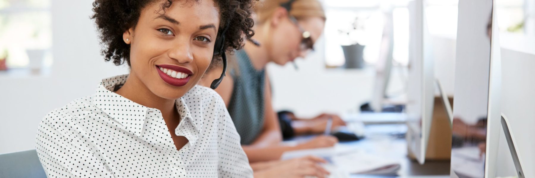 woman instructor training solutions in front of the computer smiling